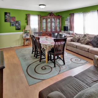 A cozy living room with green walls and a combined dining area.
