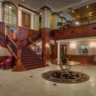 A luxurious hotel lobby with a grand staircase and elegant interior design.