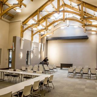A modern conference room with wooden beams and flexible seating arrangements.