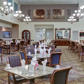 Elegant dining room interior with neatly arranged tables and chandeliers.
