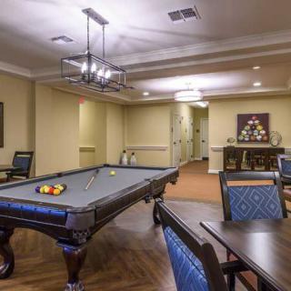 A cozy game room featuring a pool table and comfortable seating.
