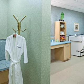 A calming spa interior with a robe on a coat rack and relaxation amenities.