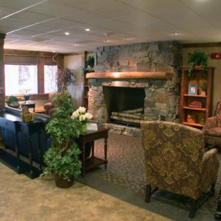 A cozy living room with a stone fireplace and comfortable seating.