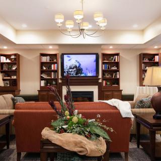 A cozy living room featuring a television, bookshelves, and comfortable seating.