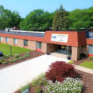 A single-story commercial building with landscaped surroundings and a prominent entrance.