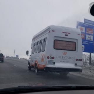 A view of a white bus driving on the highway.