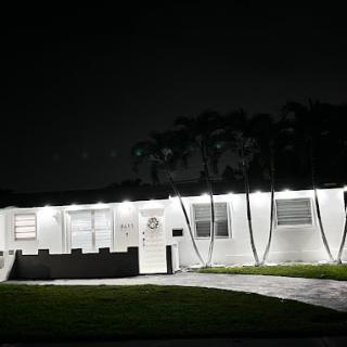 A well-lit house exterior captured during the night.