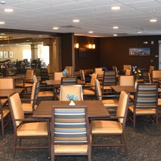An empty dining area with neatly arranged tables and chairs, ready for guests.