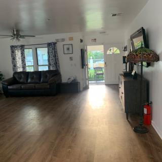 A spacious living room with hardwood floors, featuring a sofa and an open doorway.