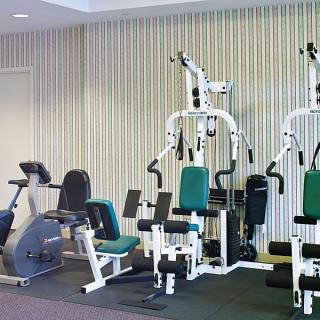 A gym room featuring various exercise machines and fitness equipment.