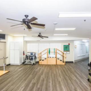 A rehabilitation facility featuring exercise equipment and a small staircase for physical therapy.