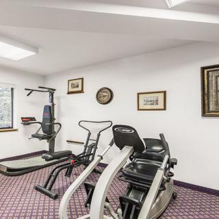 A small gym room with exercise equipment including a treadmill and stationary bike.