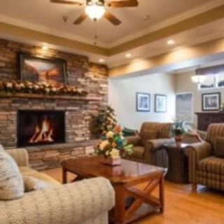 A cozy living room with a stone fireplace and comfortable seating.