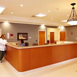 Reception area with a large desk and overhead lighting.