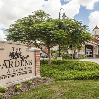 Entrance to The Gardens at Brook Ridge with a welcoming sign and lush greenery.