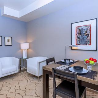A modern living and dining area with stylish furniture and wall art.