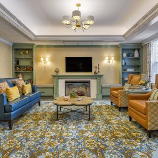 A well-decorated living room featuring comfortable seating, a fireplace, and modern lighting.
