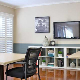 A modern office space with a desk, chair, and organized shelving.
