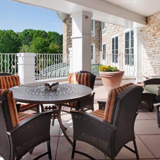 A cozy outdoor patio with a table and chairs overlooking a scenic nature view.