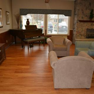 A cozy living room with a piano and comfortable seating.