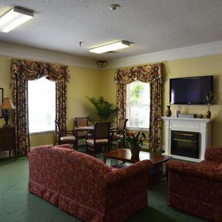 A cozy living room with sofas, a coffee table, and a fireplace beneath a wall-mounted television.