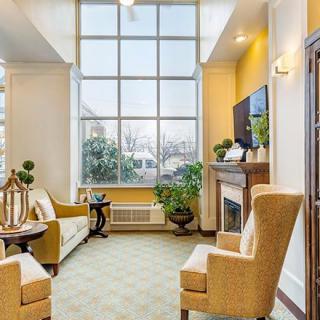 A cozy living room with large windows, comfortable seating, and natural light.