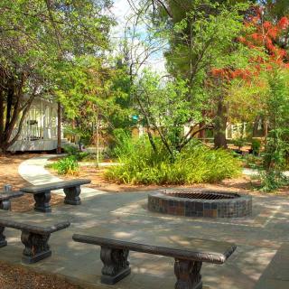 A tranquil park setting with stone benches and lush greenery.