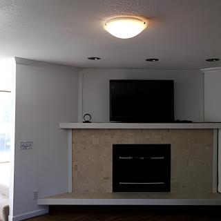 A modern living room with a minimalist design, featuring a fireplace and mounted television.