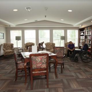 A cozy library space with comfortable seating and large windows.