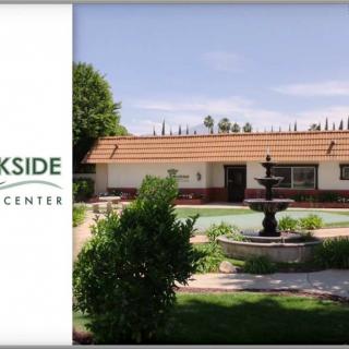 A tranquil view of a rehabilitation center with a central fountain and landscaped garden.