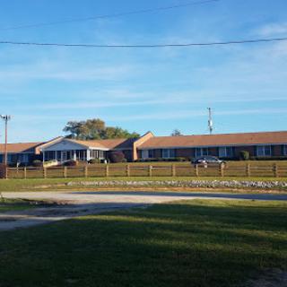 A view of a motel set against a clear blue sky, surrounded by greenery.