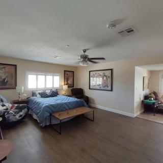 A spacious bedroom with a large bed, hardwood floors, and cozy furnishings.