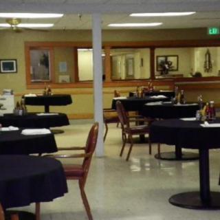 An empty restaurant dining area with neatly arranged tables and chairs.