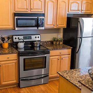 Modern kitchen with stainless steel appliances and granite countertops.