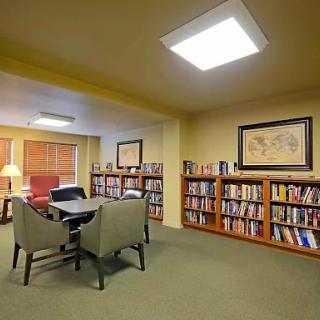 A cozy library corner featuring a collection of books and comfortable seating.