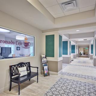 A modern office hallway featuring a bench and colorful decor.