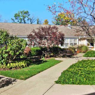A quaint house with a well-maintained garden and paved pathways.