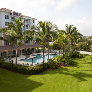 A luxurious tropical hotel with a swimming pool and lush gardens.