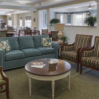 A cozy living room with a sofa, chairs, and a coffee table in an open space.