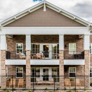 A two-story residential building with balconies and a brick facade.