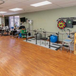 A rehabilitation room equipped with various exercise equipment for physical therapy.