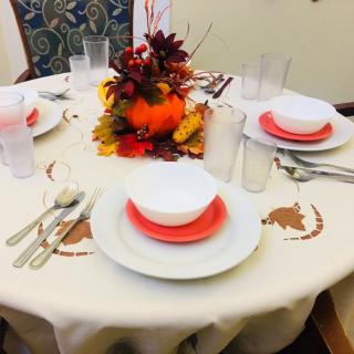 A festive autumn-themed table setting with a colorful centerpiece.