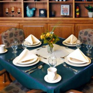 A formally set dining table with napkins, plates, and glassware arranged neatly.