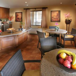 A modern kitchen and dining area featuring elegant furniture and a fruit bowl.