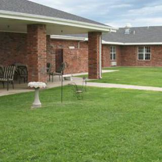 A serene courtyard with lush green grass surrounded by a brick building.