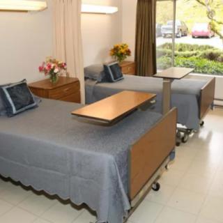 A hospital room with two beds equipped for patient care.