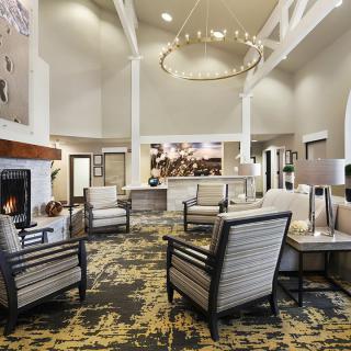 A modern hotel lobby featuring comfortable seating, a warm fireplace, and elegant lighting fixtures.