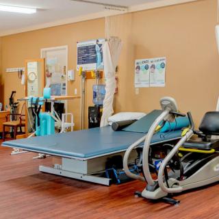 A rehabilitation center equipped with therapeutic exercise machines and treatment beds.