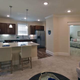 A modern open-concept kitchen and living area with contemporary furnishings and recessed lighting.