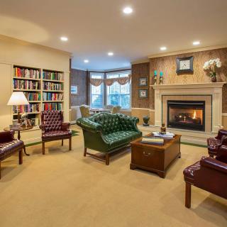 A cozy living room with a fireplace, bookshelves, and comfortable seating.